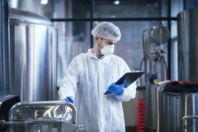 Industrial Worker White Protective Clothes Holding Checklist Reading Results X - Certified HACCP Auditor study guide