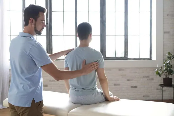 Man Helping Patient Physiotherapy Medium Shot X - Orthopedic Massage Certification study guide