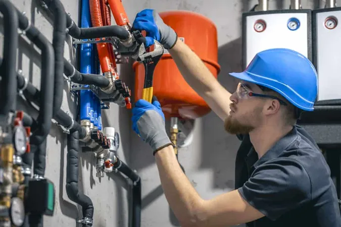 Man Installs Heating System House Checks Pipes With Wrench 1 X - Plumber Certification study guide