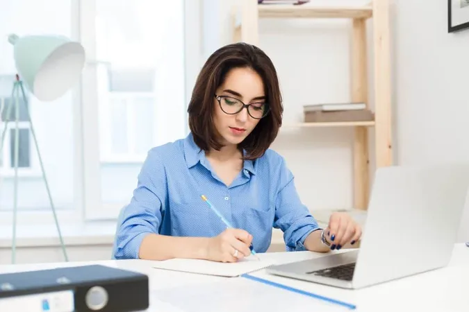 Pretty Brunette Girl Is Working Table Office She Wears Blue Shirt Black Glasses She Is Writing Seriously 1 X - Certified Research Assistant study guide