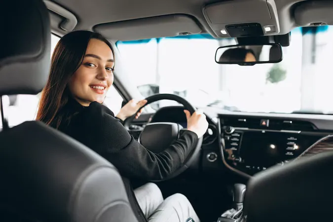 Young Woman Testing Car Car Showroom - Riding Theory Test study guide